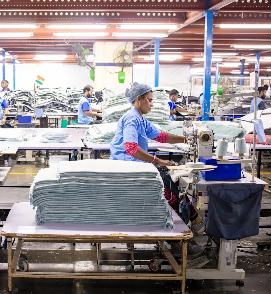 Operators stacking cut and stitched garment panels inside the Vin Cone production unit