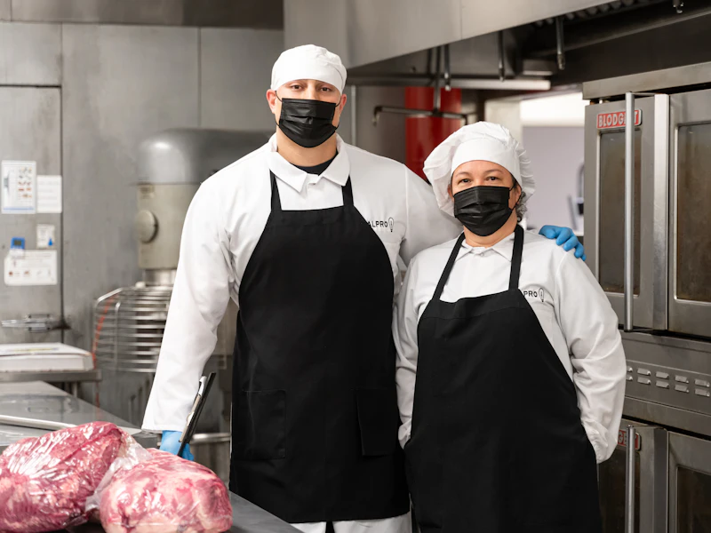 Chef in whites and an apron preparing food