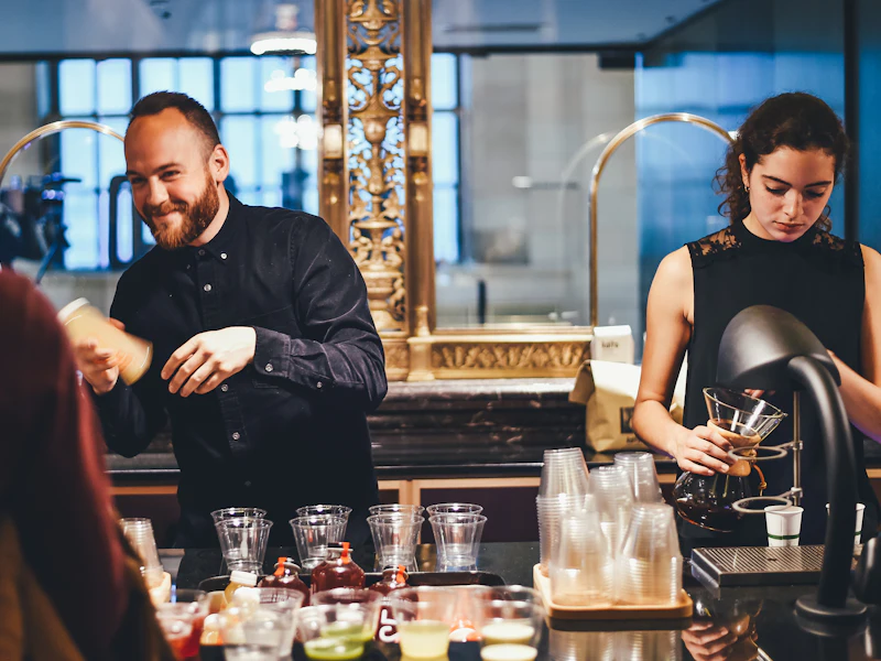 Hospitality staff serving behind a café counter in uniform