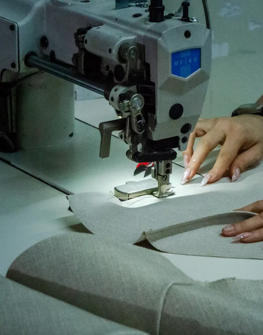 Close-up of fabric panels being joined on an industrial sewing machine